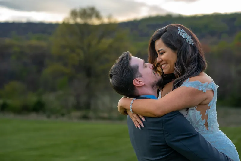 He lifts her off her feet, the Blue Ridge behind them