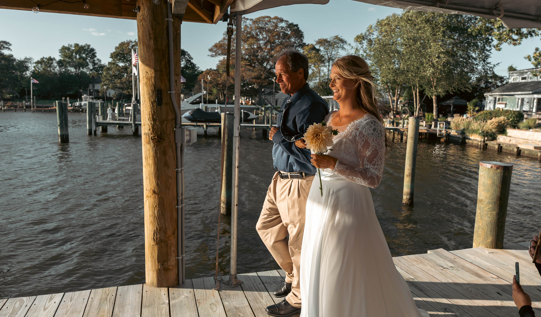 The bride walking down the dock to the ceremony — backyard wedding in Annapolis, Maryland
