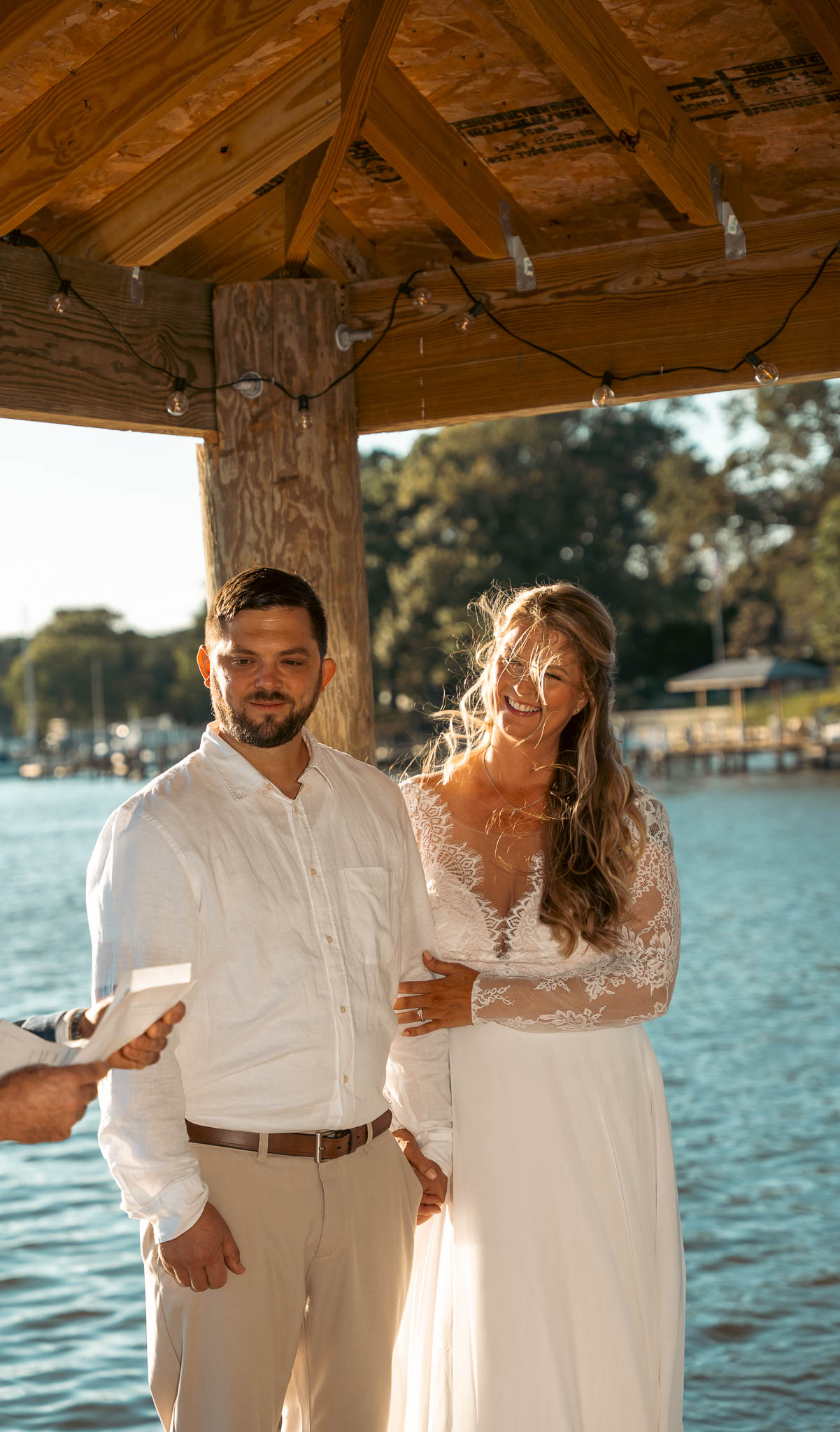 Waterfront ceremony under the boathouse roof — backyard wedding in Annapolis, Maryland