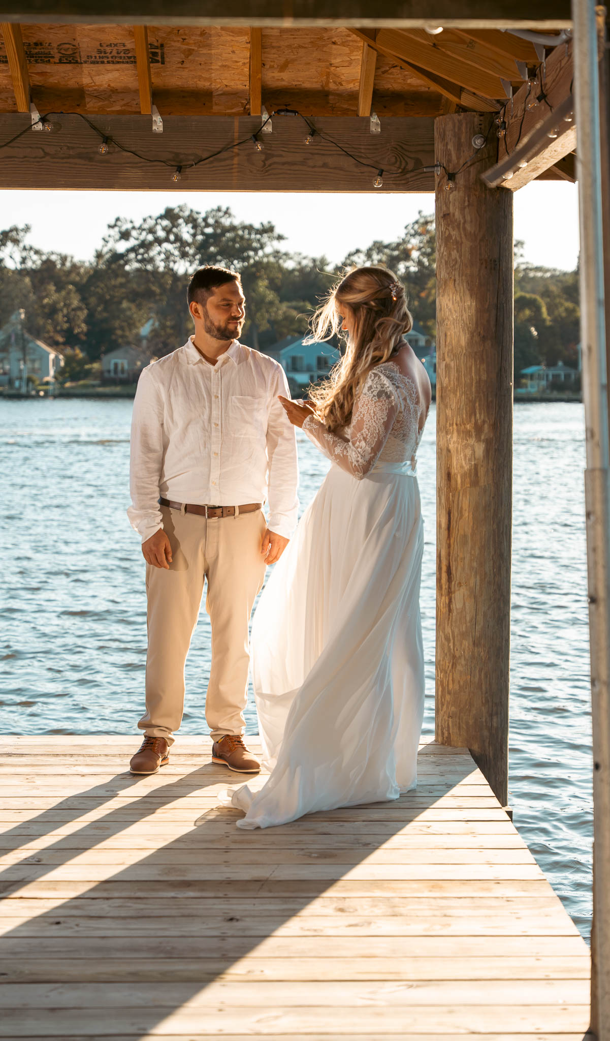 Waterfront ceremony under the boathouse roof — backyard wedding in Annapolis, Maryland