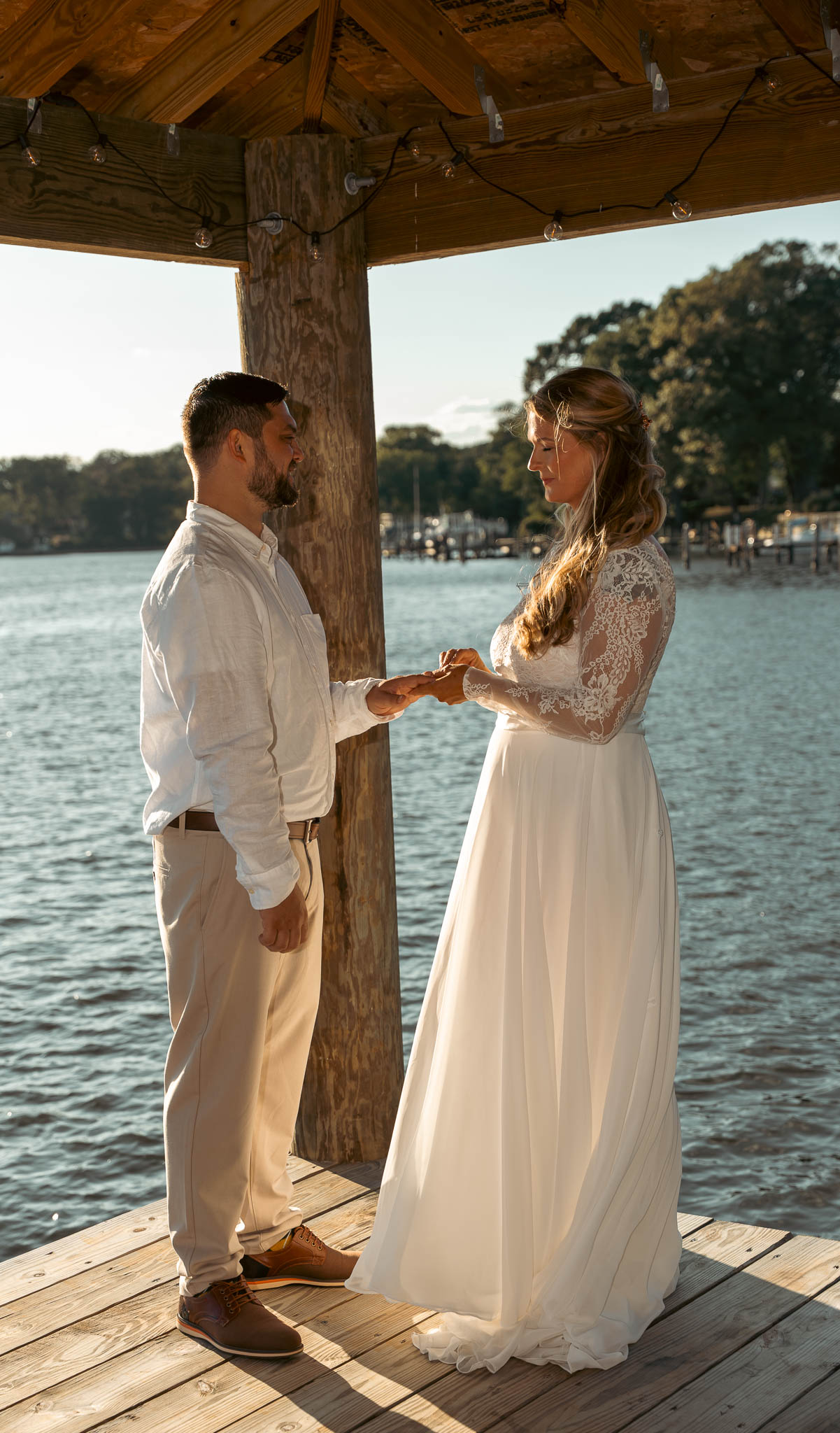 Waterfront ceremony under the boathouse roof — backyard wedding in Annapolis, Maryland