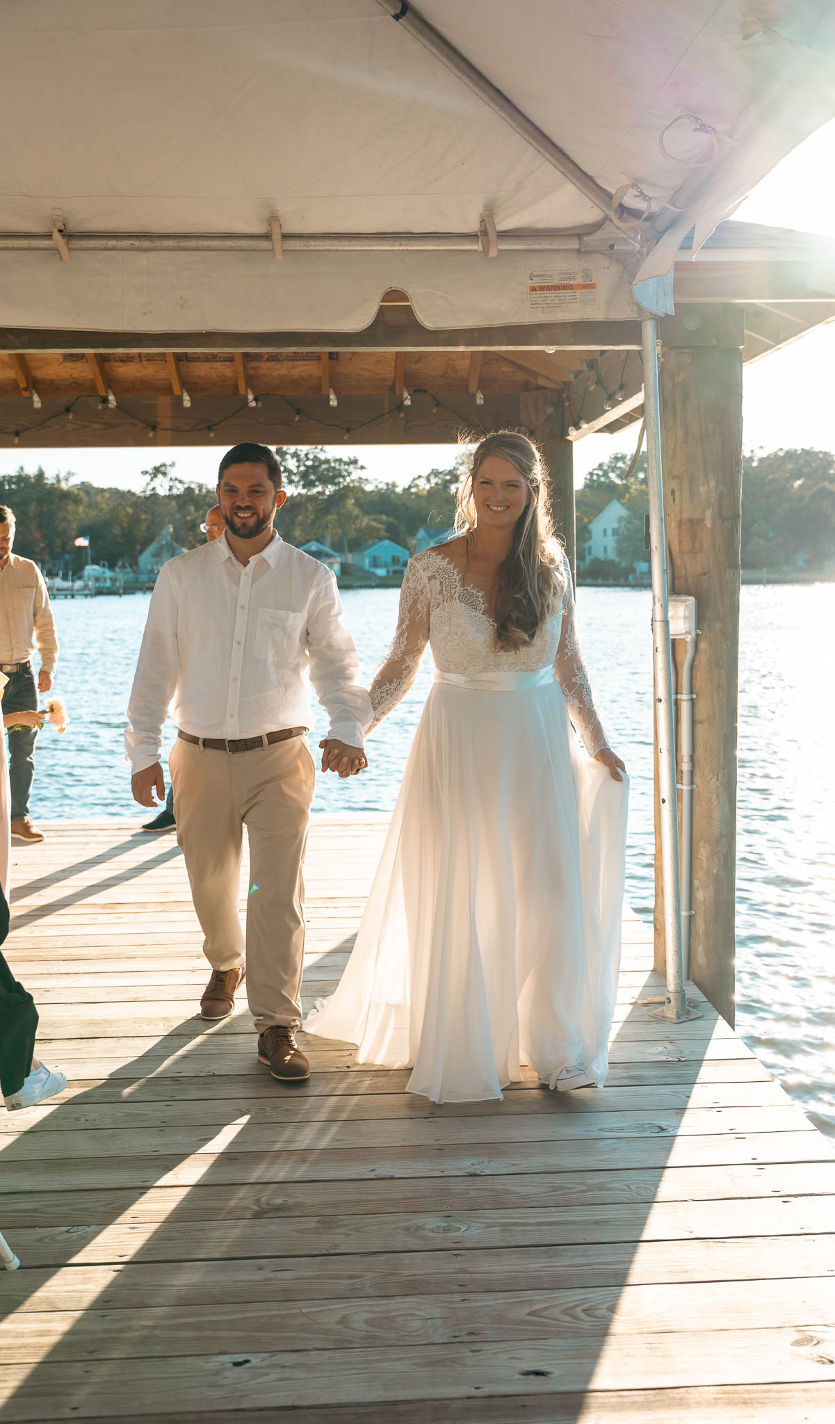 The couple walking back up the dock after their vows — backyard wedding in Annapolis, Maryland