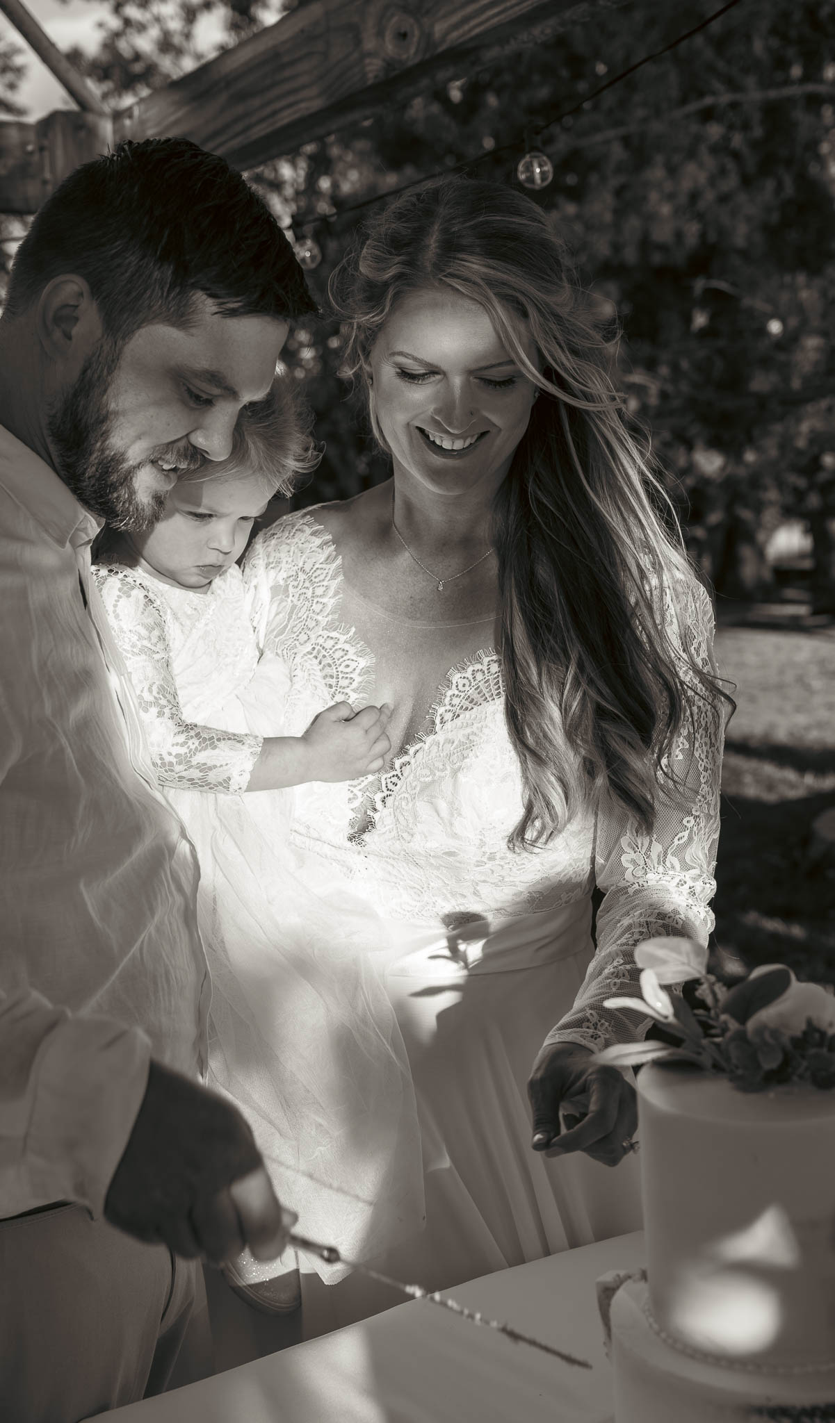 The couple cutting their wedding cake outdoors — backyard wedding in Annapolis, Maryland