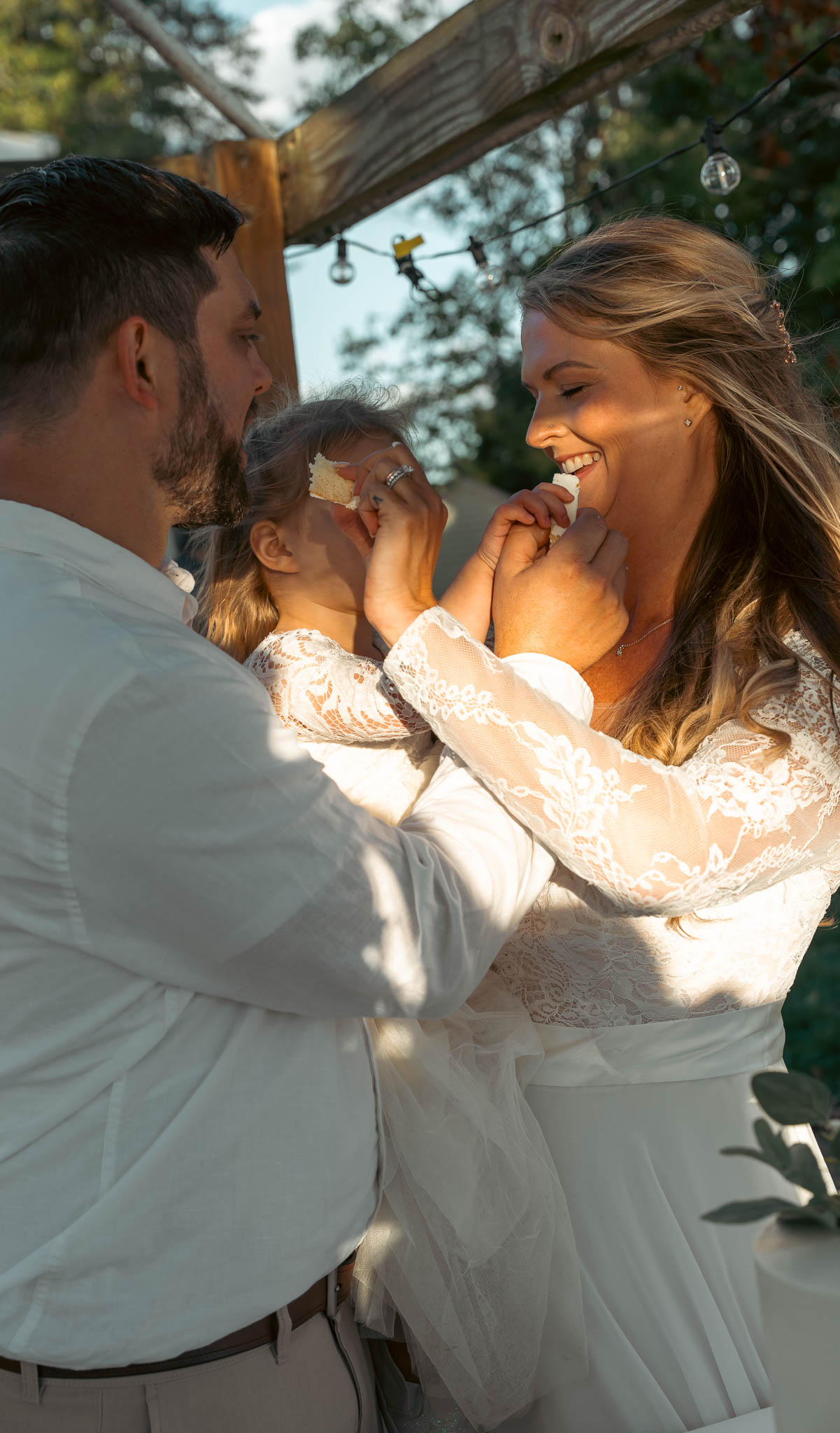 Bride and groom cutting the cake under the pergola — backyard wedding in Annapolis, Maryland