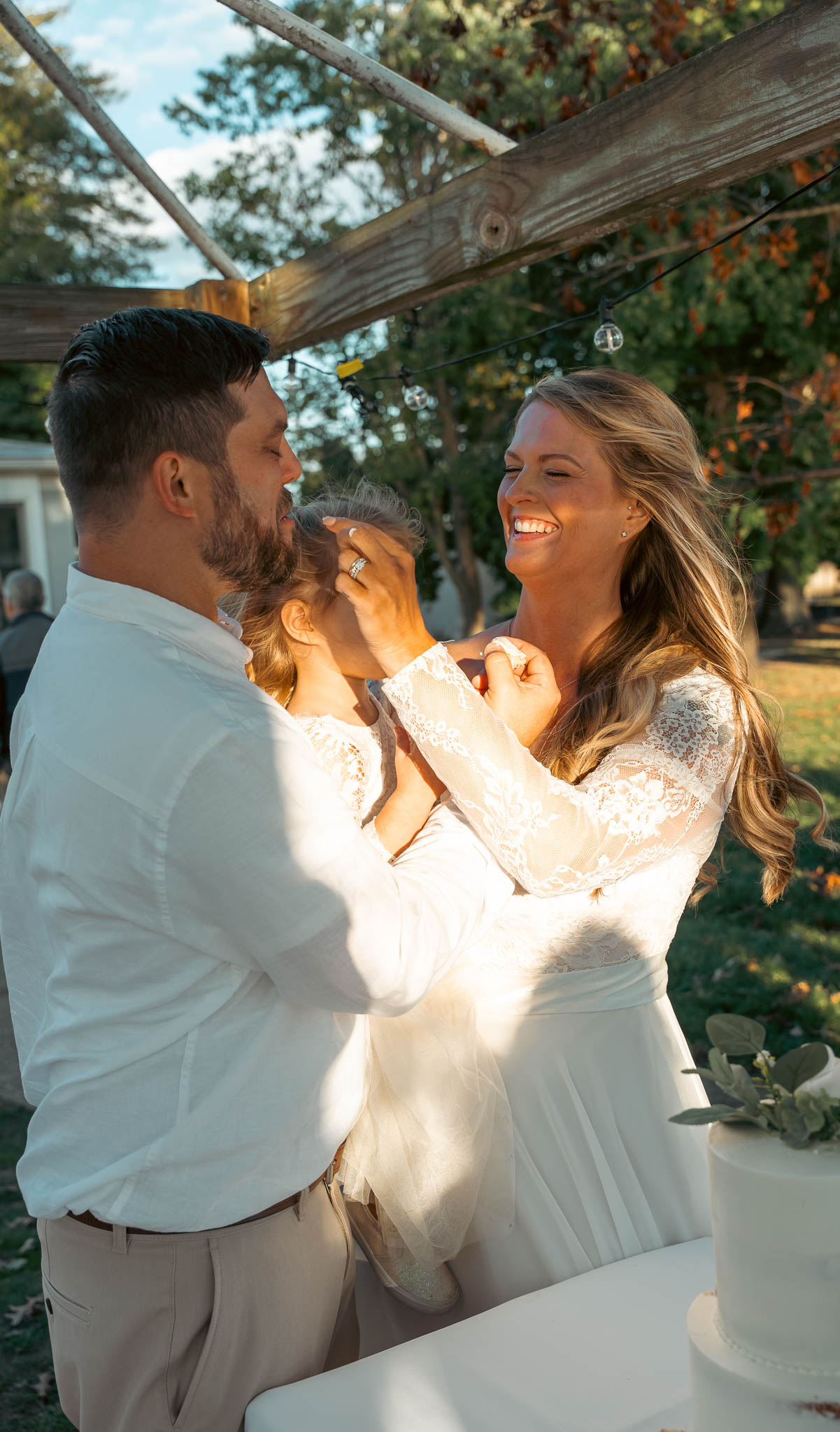 The couple cutting their wedding cake outdoors — backyard wedding in Annapolis, Maryland