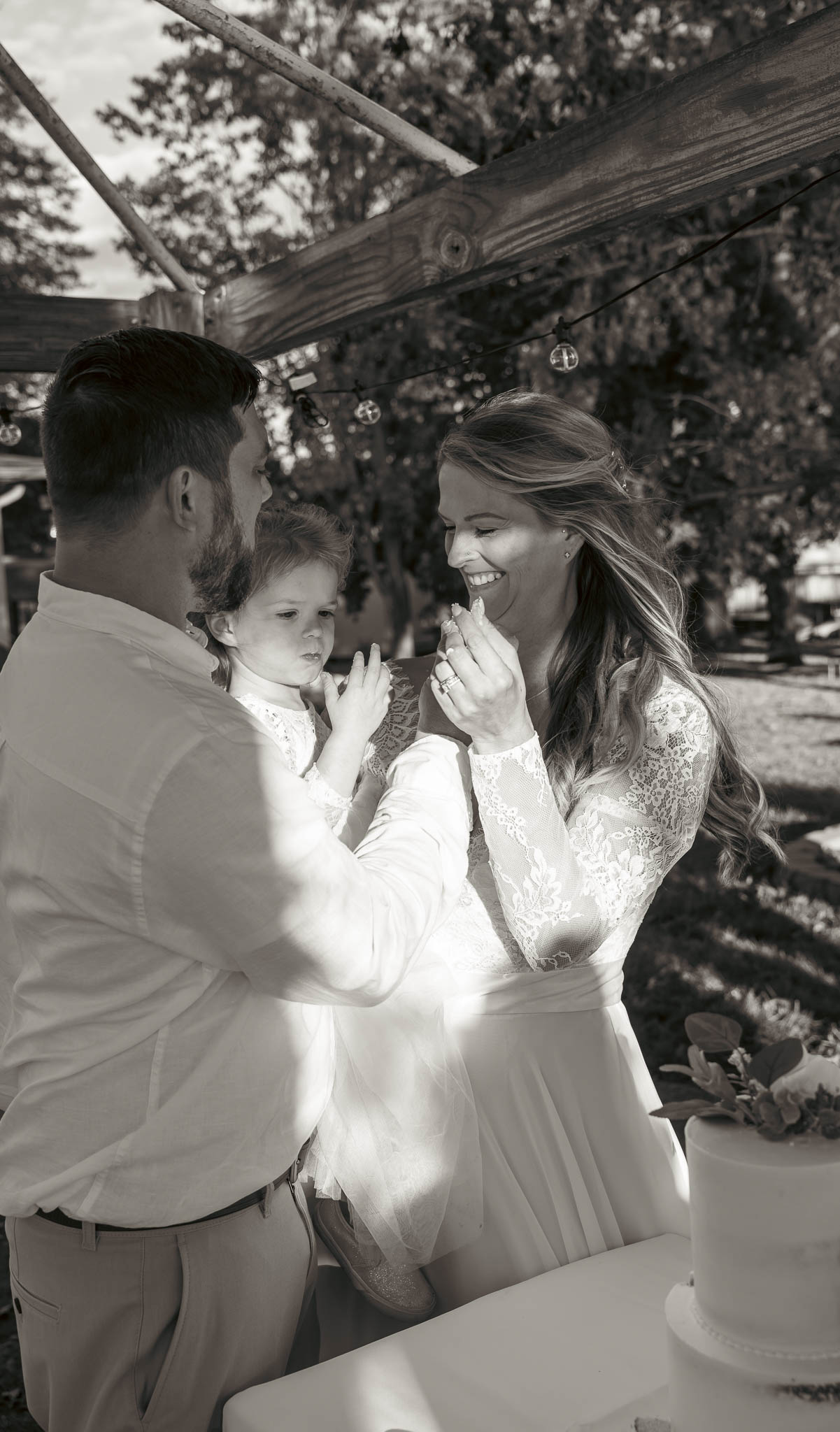 Bride and groom cutting the cake under the pergola — backyard wedding in Annapolis, Maryland