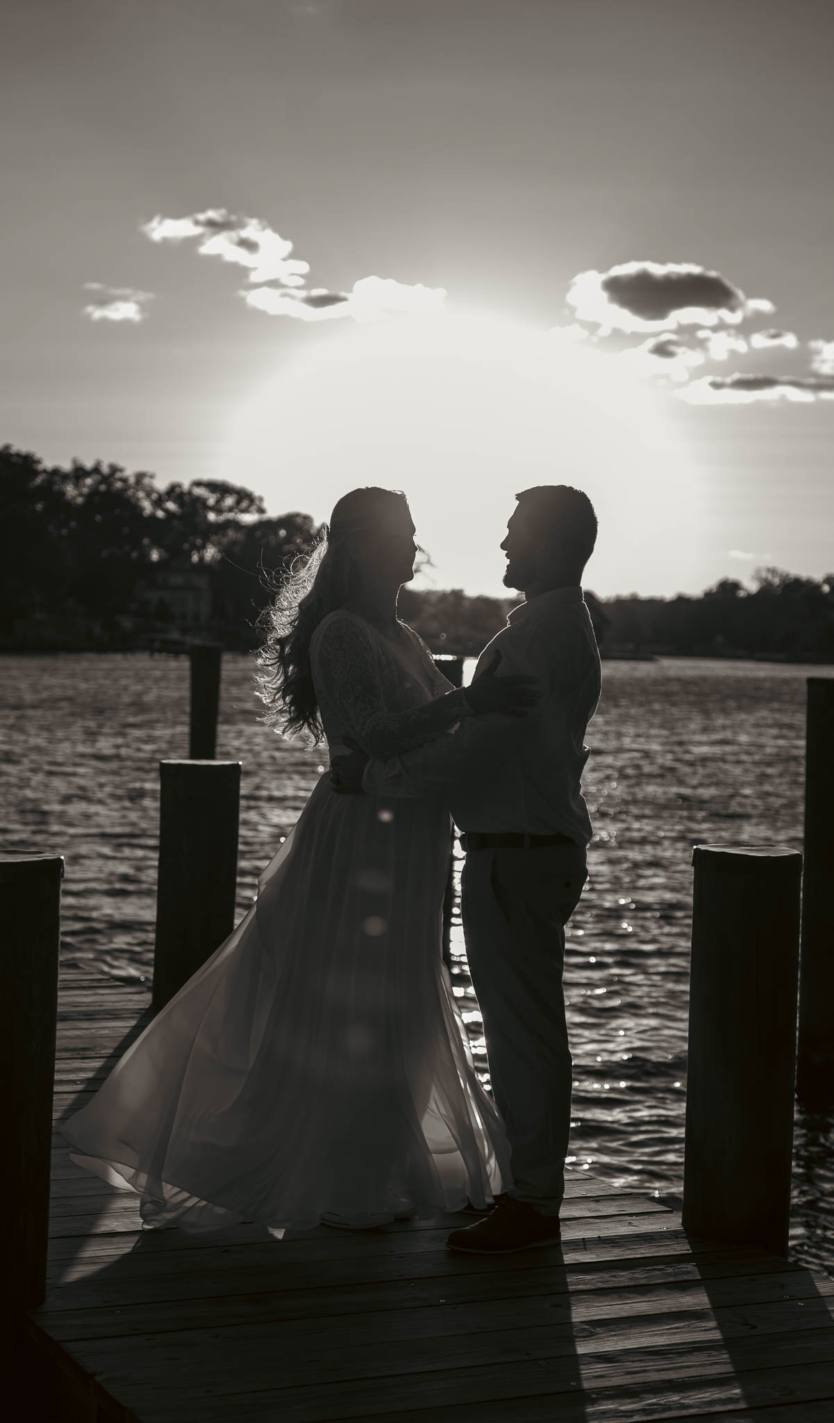 Bride and groom silhouetted against the sunset over the creek — backyard wedding in Annapolis, Maryland