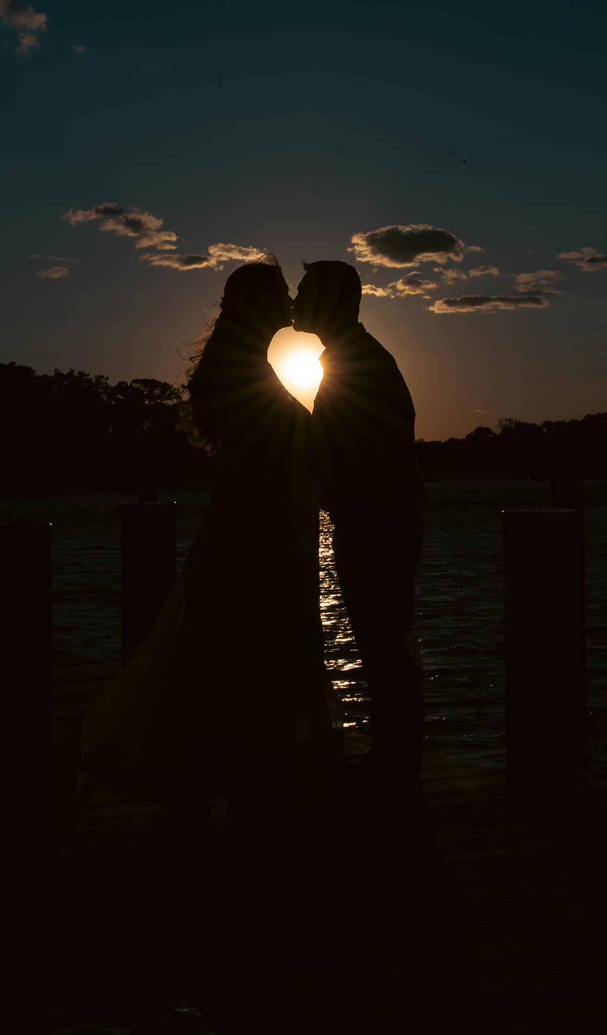 Bride and groom silhouetted against the sunset over the creek — backyard wedding in Annapolis, Maryland