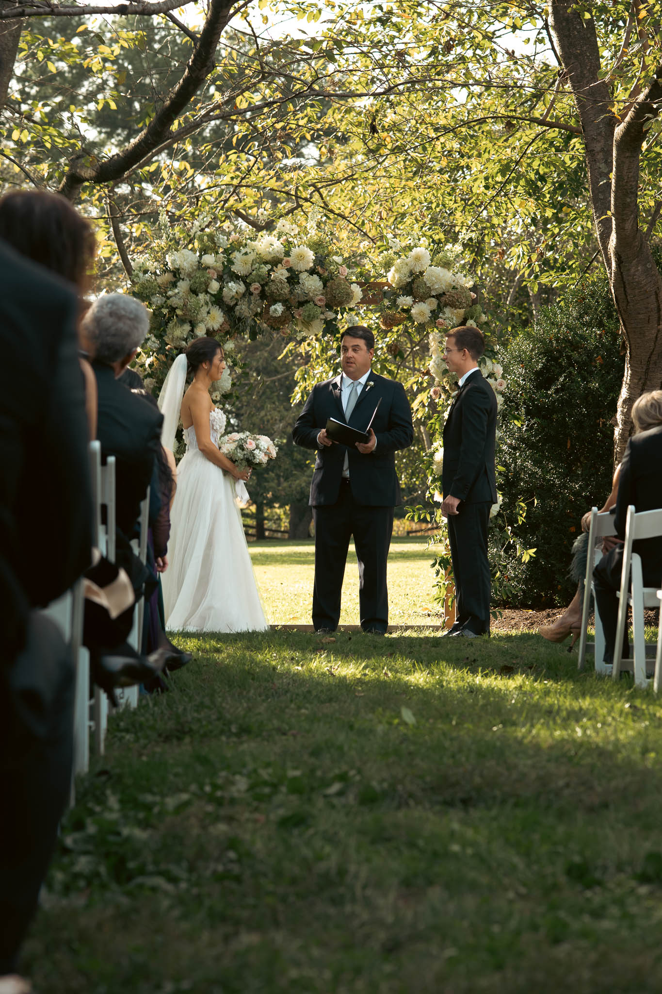 The ceremony under the oaks on an October afternoon — Sylvanside Farm wedding in Purcellville, Virginia