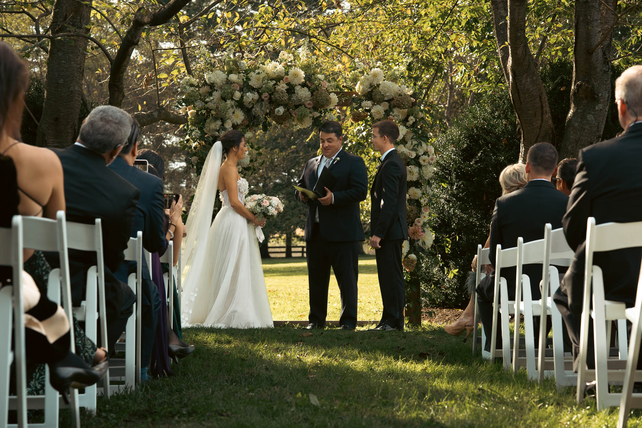 Lawn ceremony under a floral arch — Sylvanside Farm wedding in Purcellville, Virginia