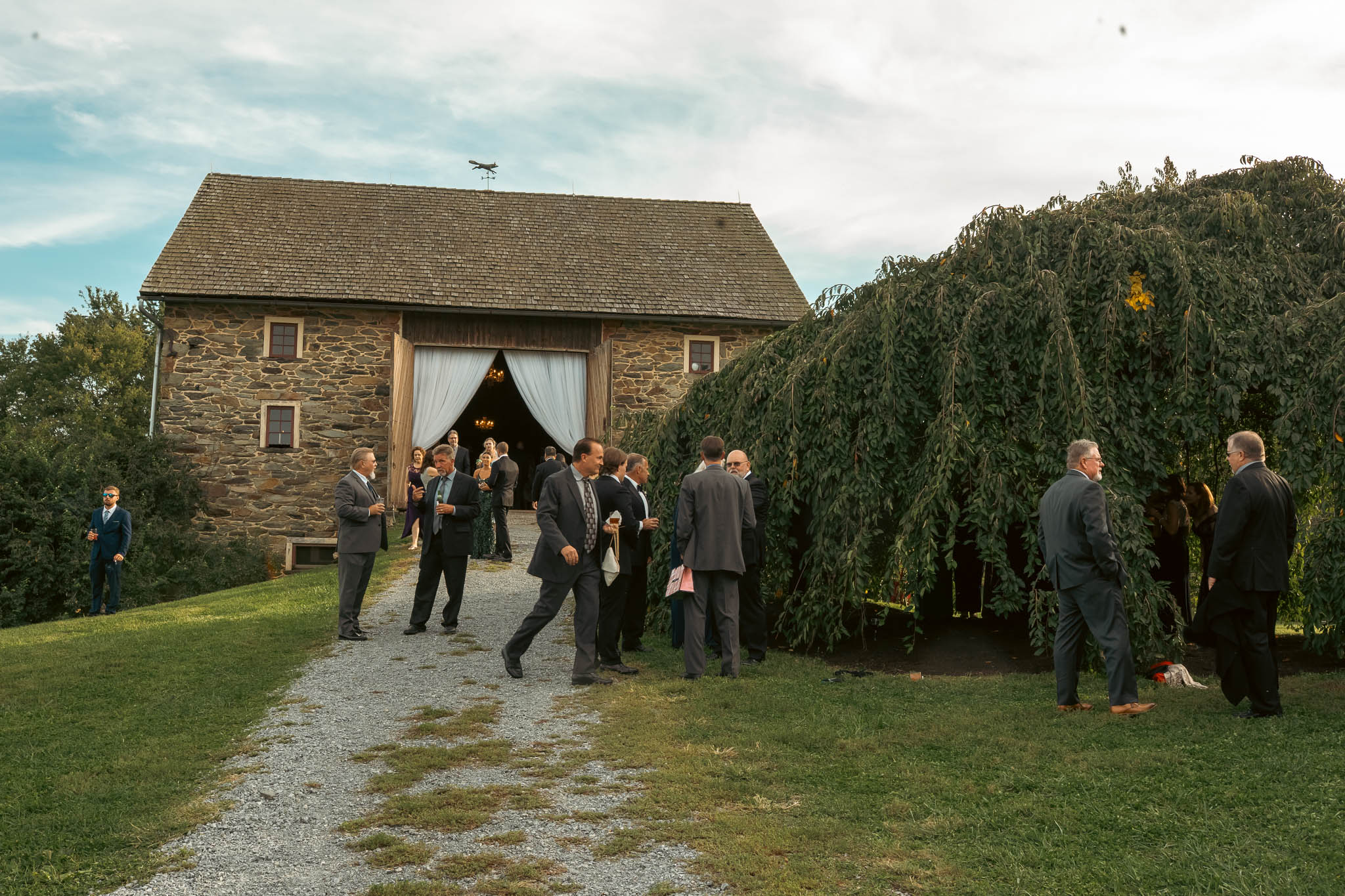 Guests at cocktail hour on the farm lawn — Sylvanside Farm wedding in Purcellville, Virginia