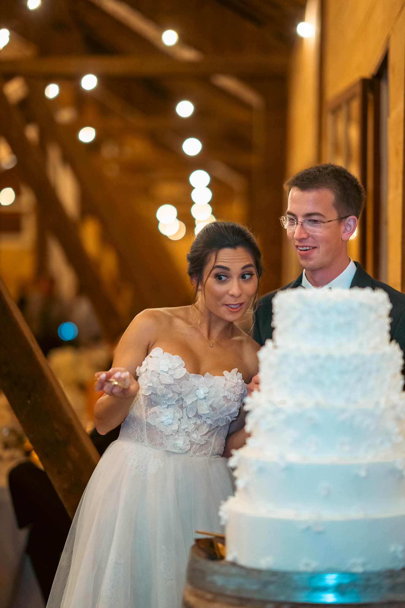 The couple cutting their wedding cake in the barn — Sylvanside Farm wedding in Purcellville, Virginia