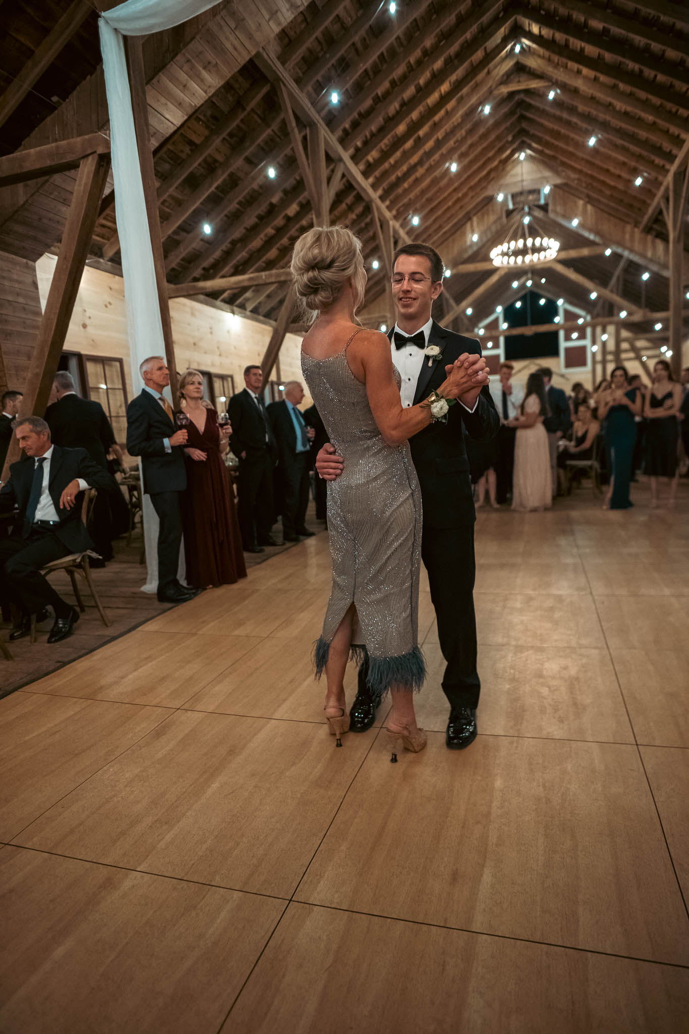 Mother-son dance under the barn string lights — Sylvanside Farm wedding in Purcellville, Virginia